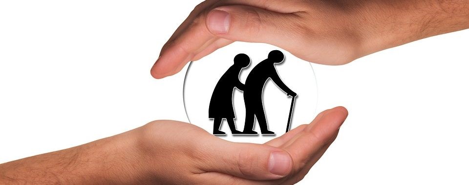 Obrazek przedtsawiający dwie dłonie a wewnątrz nich piktogram przedstawiający dwoje starszych ludzi.